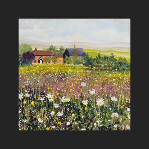 a photograph of a glass coaster which contains a fine art print of a landscape painting. There is a pretty cottage in the distance and lots of flowers in the foreground including daisies and nettles